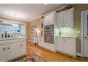 Bright kitchen featuring white cabinetry, stainless steel appliances, and hardwood floors at 6360 Brookline Ct, Cumming, GA 30040
