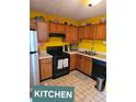 Functional kitchen featuring black appliances and oak cabinets for efficient cooking at 6424 W Charter Way, Lithonia, GA 30058