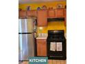 Eat-in kitchen with tile floors, wooden cabinets, and a stainless refrigerator at 6424 W Charter Way, Lithonia, GA 30058