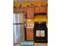 Cozy kitchen with warm wood cabinetry and stainless steel refrigerator at 6424 W Charter Way, Lithonia, GA 30058