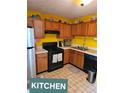 Eat-in kitchen with tile floors, wooden cabinets, and a black gas range at 6424 W Charter Way, Lithonia, GA 30058