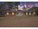 Charming single-story brick home featuring a welcoming front porch, photographed at dusk at 999 Chestnut Oak Ct, Lawrenceville, GA 30046