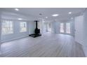 Finished basement featuring a wood-burning stove, recessed lighting, and light grey wood-look flooring at 341 Baggett Cir, Lawrenceville, GA 30044
