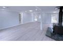 Spacious finished basement with stone accent wall, modern lighting, and newly installed light grey floors at 341 Baggett Cir, Lawrenceville, GA 30044