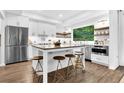 Bright, spacious kitchen features stainless steel appliances, a large island with seating, and wood flooring at 3882 The Ascent Ne, Brookhaven, GA 30319