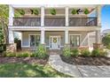 Close up of a charming porch that includes stone columns, wooden railings and hanging potted plants at 2742 Oak Village Trl, Decatur, GA 30032