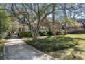 A brick home nestled among mature trees with a long driveway and lush, green landscaping at 595 Ridgecrest Ne Rd, Atlanta, GA 30307