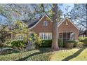 Charming brick home with a blue door, stone archway and a screened-in porch nestled among mature trees at 595 Ridgecrest Ne Rd, Atlanta, GA 30307