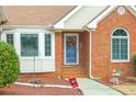 Inviting front entrance with brick facade, decorative window, and seasonal wreath on the door at 3533 Saddlebrook Dr, Loganville, GA 30052