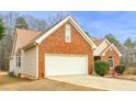 View of brick and vinyl sided house with attached garage and manicured landscaping at 3533 Saddlebrook Dr, Loganville, GA 30052
