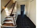 View of the entryway with slate flooring and a staircase with wood treads at 4617 N Peachtree Rd, Dunwoody, GA 30338