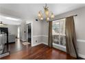 Traditional dining room with hardwood floors, chandelier, and large window with natural light at 1007 Crown River Pkwy, Mcdonough, GA 30252