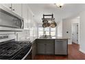 Modern kitchen with granite counters, stainless steel appliances, and a stylish pot rack at 1007 Crown River Pkwy, Mcdonough, GA 30252