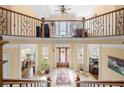 Open foyer with a balcony overlooking the grand entrance with decorative iron railing and travertine flooring at 3017 Canton Pines, Marietta, GA 30068