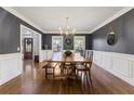 Formal dining room with dark walls, wainscoting, hardwood floors, and a large wooden dining table at 1701 Crowes Lake Ct, Lawrenceville, GA 30043
