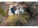 Aerial view of the home with a large backyard, patio set, and a fire pit at 6935 Autumn Hills Dr, Cumming, GA 30028