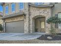 Inviting covered front entrance with stone detail, a two-car garage, and a well-maintained lawn at 316 Silverwood Dr, Dallas, GA 30157