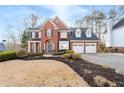 Beautiful brick home with a well-manicured lawn and three-car garage, offering curb appeal at 1026 Wellesley Crest Dr, Woodstock, GA 30189