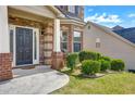 Inviting front entrance with brick columns, manicured bushes, and a modern black door at 9710 Rabun Way, Jonesboro, GA 30238