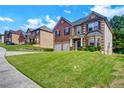 Traditional brick and siding home with a well-manicured lawn and two-car garage at 9710 Rabun Way, Jonesboro, GA 30238