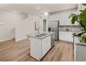Bright kitchen featuring an island with a sink, stainless steel fridge, and hardwood floors at 9472 Cedar Grove Ct # 237, Jonesboro, GA 30238