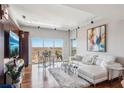 Bright living room featuring hardwood floors, a large window with an open view, and a comfortable white couch at 4561 Olde Perimeter Way # 2609, Atlanta, GA 30346