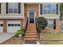 Close-up of the brick entrance stairs leading up to a black front door with an arched window above at 4224 Berkeley Mill Close, Duluth, GA 30096