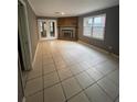 Bright living room featuring tile floors, a brick fireplace and double doors that lead to the backyard at 4762 Old Highgate Entry, Stone Mountain, GA 30083