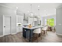 Modern kitchen boasts a center island, white cabinetry, pendant lighting, and stainless steel appliances at 1101 Cooks Farm Way, Woodstock, GA 30189