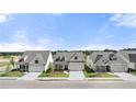An eye-level view showcasing three gorgeous homes, surrounded by lush lawns with an inviting street and beautiful cloudscape at 1649 Tielman Way, Snellville, GA 30078