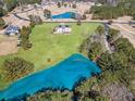 A breathtaking aerial view reveals a home with spacious green grounds, and an adjacent serene pond at 525 Waters Way, Fayetteville, GA 30215