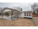 Attached carport featuring durable gray painted concrete and exterior screened-in porch at 7445 Paul Ct, Riverdale, GA 30274