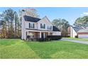 Attractive two-story home featuring a cozy front porch and lush green lawn at 12 Windcrest, Covington, GA 30016