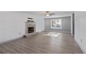 Bright living room featuring a cozy stone fireplace and ceiling fan at 12 Windcrest, Covington, GA 30016