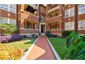 Lush landscaping leads to the front entrance of this charming red brick apartment building at 198 Ponce De Leon Ne Ave # 5D, Atlanta, GA 30308