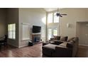 Spacious living room with high ceilings, a fireplace, and a comfortable brown sectional couch at 2820 Skye Ter, Duluth, GA 30096
