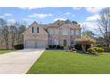 Charming brick two-story home with a well-manicured lawn and a two-car garage at 330 Meadowcrest Cir, Canton, GA 30115