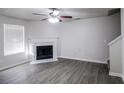 Bright living room featuring a fireplace, modern ceiling fan, and beautiful laminate wood flooring at 844 Glenshire Ct, Riverdale, GA 30274