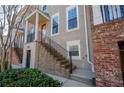 This townhome has a private entrance with brick stairs leading to the main level and a red front door at 961 Persimmon Pt, Atlanta, GA 30328