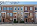 Exterior view of charming townhomes featuring brick and neutral siding with well-manicured landscaping at 961 Persimmon Pt, Atlanta, GA 30328
