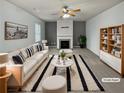 Bright living room with fireplace, ceiling fan, neutral paint, and modern furnishings at 4963 Arbor View Nw Pkwy, Acworth, GA 30101
