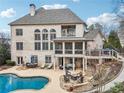 Expansive backyard featuring a pool, patio, screened porch, and lush landscaping in a stunning two-story home at 10235 Worthington Mnr, Suwanee, GA 30024