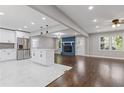 Open-concept kitchen featuring white cabinets, stainless steel appliances, and a cozy living area at 5277 Cardinal Nw Ln, Lilburn, GA 30047