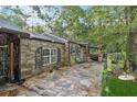 Stone home featuring a flagstone patio, lush landscaping, and unique architectural details, perfect for outdoor living at 80 Rountree Rd, Riverdale, GA 30274