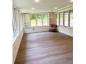 Bright sunroom with large windows, white brick walls, and wood-style flooring at 1332 Willis Mill Sw Rd, Atlanta, GA 30311