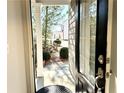 Charming view from the open front door, showcasing the welcoming exterior and landscaped yard at 3275 Wild Basil Ln, Buford, GA 30519