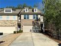 Townhome exterior view of the garages, driveways, and landscaped lawns on a bright, sunny day at 3275 Wild Basil Ln, Buford, GA 30519