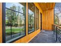Covered porch with wood-paneled walls, black framed windows and door, and slate tile flooring at 2949 Laguna Dr, Decatur, GA 30032