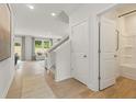 Bright entryway featuring wood-look floors, stairs to the second level, and a door to the bathroom at 5523 Rosehall Pl, Atlanta, GA 30349