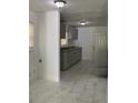 Well-lit kitchen area with gray cabinets, a door to the side and marble tiled floor at 1649 Ezra Church Nw Dr, Atlanta, GA 30314